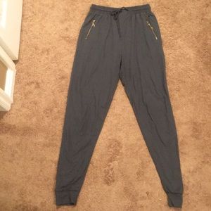 Gray jogger pants with gold zippers